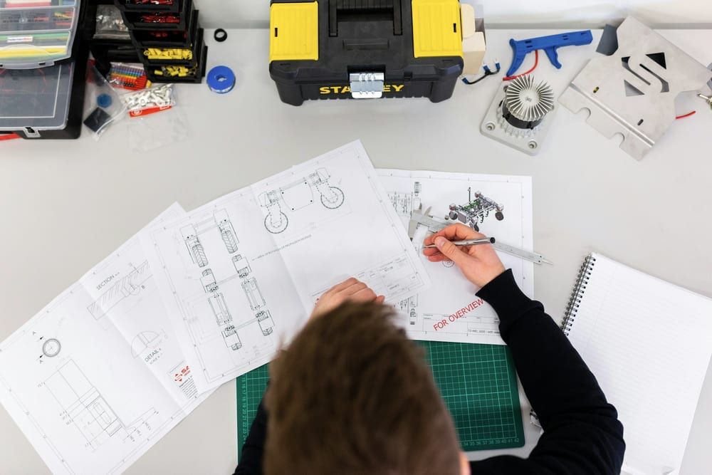 Overhead view of a hand-drawn technical plan with ruler, pencil and toolbox